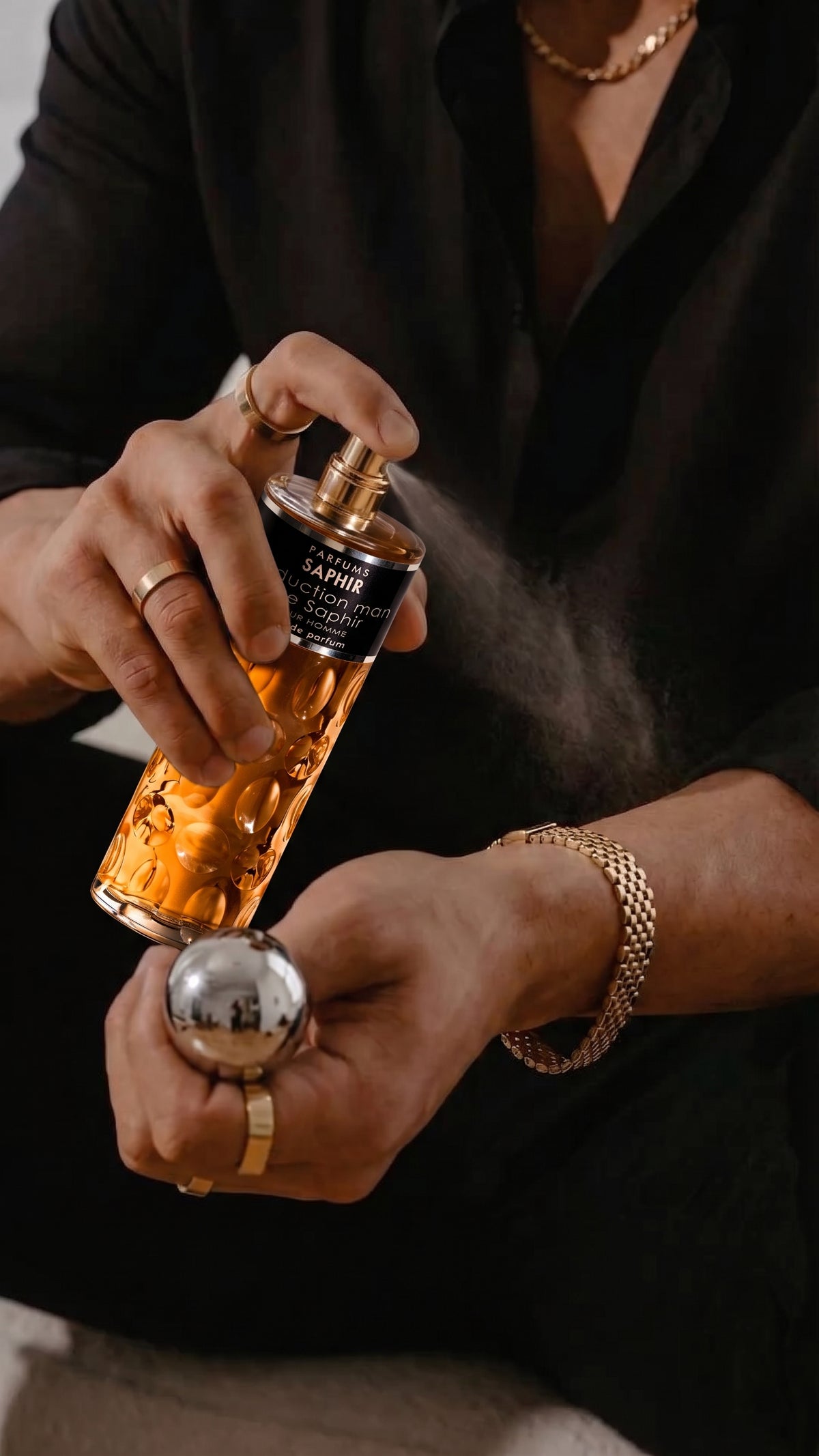 Man spraying Seduction Man de Saphir cologne on wrist, close-up detail